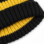 Gros plan texture coton tricoté noir et jaune du bonnet-écharpe